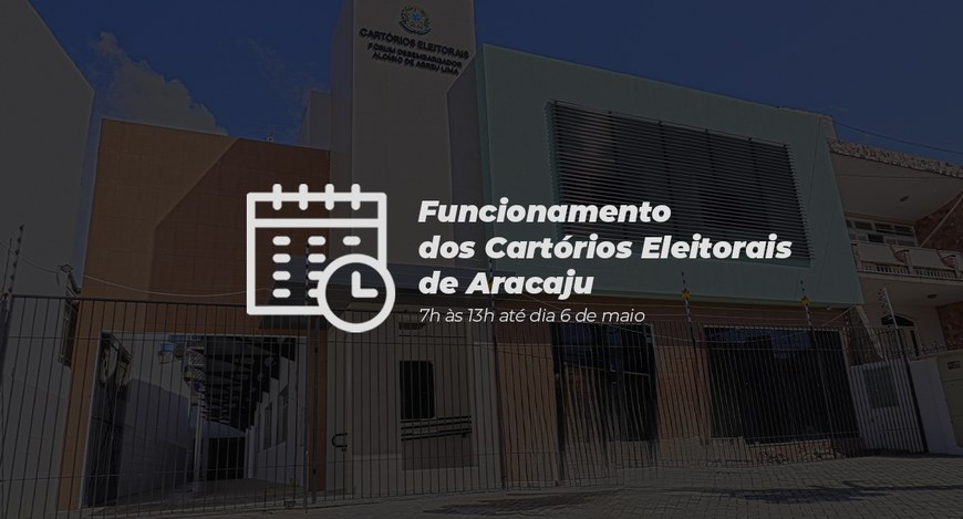 Imagem de um prédio institucional moderno, visto de frente, com fachada clara e detalhes em verd...