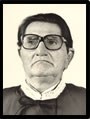 Foto de busto preta e branca do Desembargador Antônio Machado usando toga e óculos.