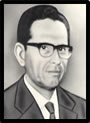 Foto de busto do Desembargador Luciano França Nabuco usando terno escuro, gravata e óculos.